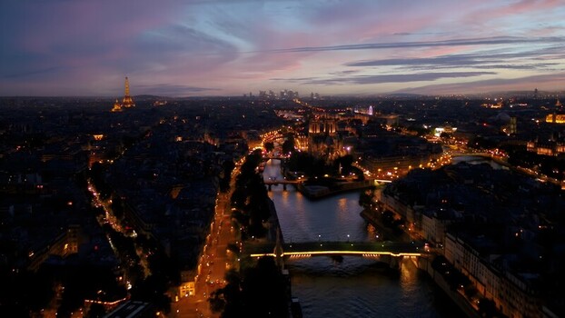 Aerial view of the Eiffel Tower and Notre Dame Cathedral illuminated at dusk over the Seine River in Paris Ile de France France. Aerial view of the Eiffel Tower and Notre Dame Cathedral illuminated at dusk over the Seine River in Paris Ile de France France.