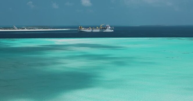 Aerial view of a large industrial ship in turquoise waters Maldives. Aerial view of a large industrial ship in turquoise waters Maldives.