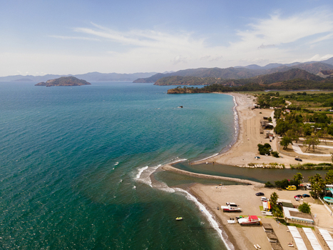 Aerial view of Karaot Beach with its sandy coastline turquoise Aegean Sea small boats moored on the shore and surrounding hills in Fethiye Mugla Turkiye. Aerial view of Karaot Beach with its sandy coastline turquoise Aegean Sea small boats moored on the shore and surrounding hills in Fethiye Mugla Turkiye.
