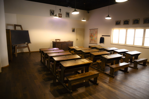 View of a historic classroom with wooden desks a teacher s desk and a chalkboard in a school museum in Gdansk Pomeranian Voivodeship Poland. View of a historic classroom with wooden desks a teacher s desk and a chalkboard in a school museum in Gdansk Pomeranian Voivodeship Poland.