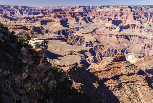 View of the Grand Canyon featuring deep rocky gorges layered geological formations and rugged cliffs under bright daylight in Coconino County Arizona United States. View of the Grand Canyon featuring deep rocky gorges layered geological formations and rugged cliffs under bright daylight in Coconino County Arizona United States.