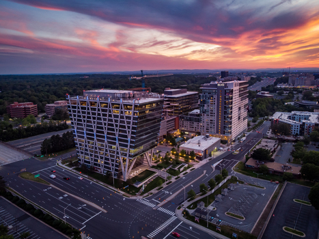 Reston Virginia United States 27 May 2020 Aerial view of modern office and residential towers at Reston Station featuring unique architecture roads and a vibrant sunset sky. Reston Virginia United States 27 May 2020 Aerial view of modern office and residential towers at Reston Station featuring unique architecture roads and a vibrant sunset sky.