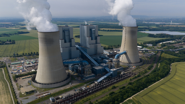 Aerial view of RWE Power AG Kraftwerk Neurath with its cooling towers emitting steam surrounded by green fields and industrial infrastructure in Grevenbroich Nordrhein Westfalen Germany. Aerial view of RWE Power AG Kraftwerk Neurath with its cooling towers emitting steam surrounded by green fields and industrial infrastructure in Grevenbroich Nordrhein Westfalen Germany.