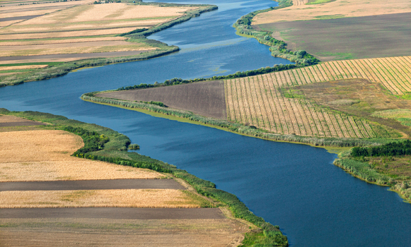 Aerial view of the meandering Begej river flowing through agricultural fields and farmlands in Perlez Vojvodina Serbia.