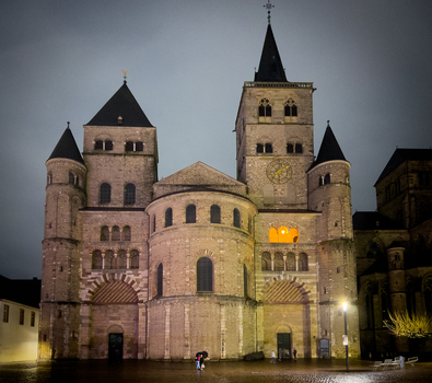 View of the historic Trier Cathedral at night featuring its Romanesque architecture stone facade and illuminated windows in Trier Rheinland Pfalz Germany.