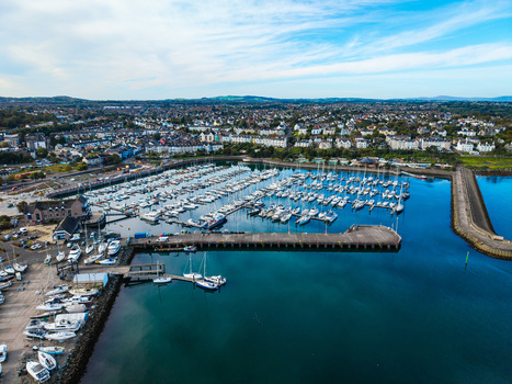 Aerial view of Bangor Harbour and Town featuring numerous sailboats moored in the marina surrounded by urban buildings and coastal landscape in Bangor Northern Ireland United Kingdom.