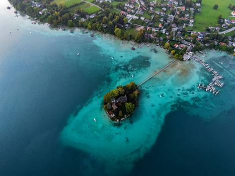 Aerial view of the small island with a historic building in Attersee surrounded by turquoise waters and a long wooden pier in Vocklabruck District Upper Austria Austria.