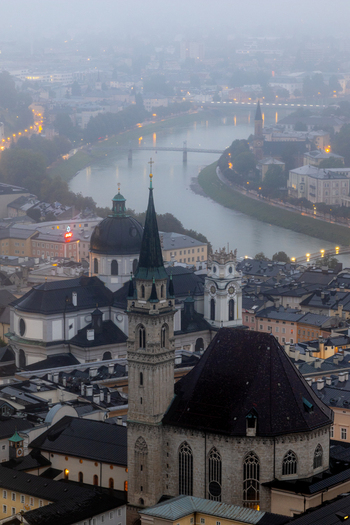 Aerial view of the historic city of Salzburg with its iconic cathedral churches and the Salzach river flowing through the urban landscape at dusk in Salzburg Salzburg Austria. Aerial view of the historic city of Salzburg with its iconic cathedral churches and the Salzach river flowing through the urban landscape at dusk in Salzburg Salzburg Austria.