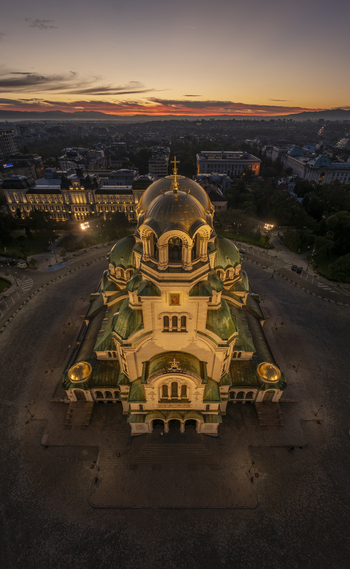 Aerial view of Patriarchal Cathedral St. Alexander Nevsky with its golden domes and green roofs illuminated at sunset in the city center Sofia Sofia City Province Bulgaria. Aerial view of Patriarchal Cathedral St. Alexander Nevsky with its golden domes and green roofs illuminated at sunset in the city center Sofia Sofia City Province Bulgaria.