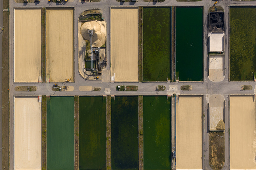 Aerial view of Ashford Common Water Treatment Works featuring rectangular filtration beds with varying water levels and industrial infrastructure in Shepperton England United Kingdom. Aerial view of Ashford Common Water Treatment Works featuring rectangular filtration beds with varying water levels and industrial infrastructure in Shepperton England United Kingdom.
