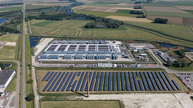 Aerial view of the HGB power plant facility with a solar panel field in the foreground surrounded by agricultural fields and canals in Winschoten Groningen Netherlands.