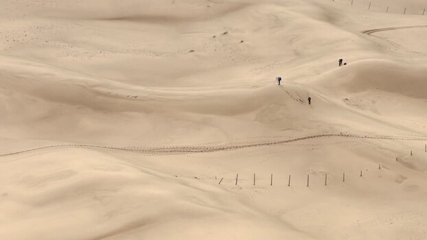 Aerial view of people hiking on sand dunes in Senek Kazakhstan. Aerial view of people hiking on sand dunes in Senek Kazakhstan.