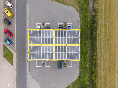 Aerial view of the Fastned charging station with solar panel roof and electric vehicles parked in Breukelen Utrecht Netherlands. Aerial view of the Fastned charging station with solar panel roof and electric vehicles parked in Breukelen Utrecht Netherlands.