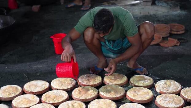 View of a man preparing traditional curd in Bogura Bangladesh. View of a man preparing traditional curd in Bogura Bangladesh.