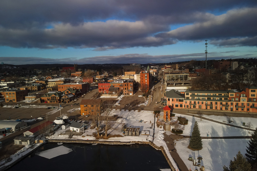 Aerial view of the Marquette waterfront and downtown area featuring historic brick buildings snow covered ground and the harbor under a cloudy sky in Marquette Michigan United States.