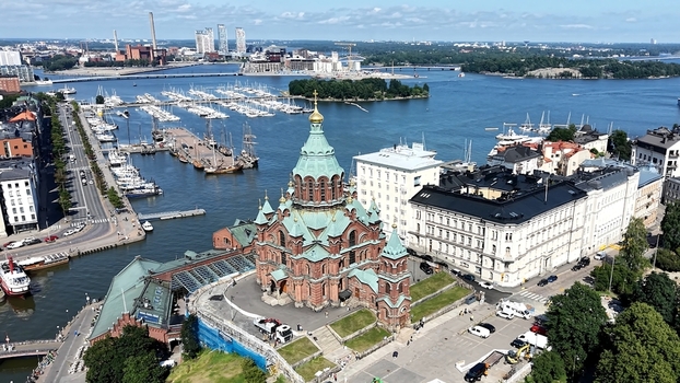 Aerial view of Uspenski Cathedral with its green domes and red brick architecture overlooking the harbor with boats and the surrounding urban landscape in Helsinki Uusimaa Finland. Aerial view of Uspenski Cathedral with its green domes and red brick architecture overlooking the harbor with boats and the surrounding urban landscape in Helsinki Uusimaa Finland.