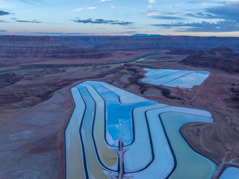 Aerial view of colorful potash evaporation ponds with vibrant blue and turquoise water set against the arid desert landscape and red rock canyons of Utah United States. Aerial view of colorful potash evaporation ponds with vibrant blue and turquoise water set against the arid desert landscape and red rock canyons of Utah United States.
