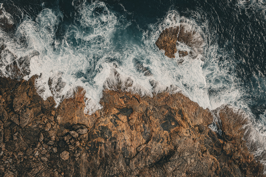 Aerial view of Conspicuous Cliff with powerful ocean waves crashing against rugged rocky coastline in Nornalup Western Australia Australia. Aerial view of Conspicuous Cliff with powerful ocean waves crashing against rugged rocky coastline in Nornalup Western Australia Australia.