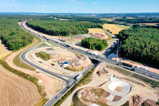 Aerial view of a highway construction site with cranes and earthworks surrounded by dense forest and agricultural fields Hochstadt Bavaria Germany. Aerial view of a highway construction site with cranes and earthworks surrounded by dense forest and agricultural fields Hochstadt Bavaria Germany.