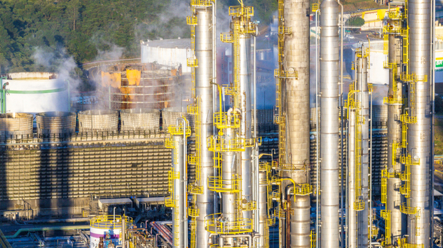 Aerial view of the petrochemical complex with tall industrial towers storage tanks and steam rising from cooling units in Santo Andre State of Sao Paulo Brazil.