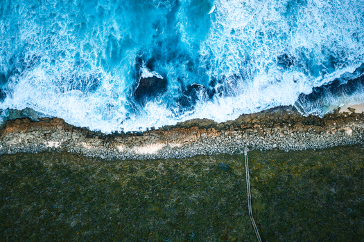 Aerial view of the Sandpatch coastline with waves crashing against rocky shores and a wooden boardwalk leading through coastal vegetation in Albany Western Australia Australia. Aerial view of the Sandpatch coastline with waves crashing against rocky shores and a wooden boardwalk leading through coastal vegetation in Albany Western Australia Australia.