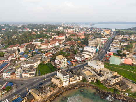 Aerial view of the urban landscape and coastal architecture with historic buildings and busy streets under a hazy sky in Galle Southern Province Sri Lanka.