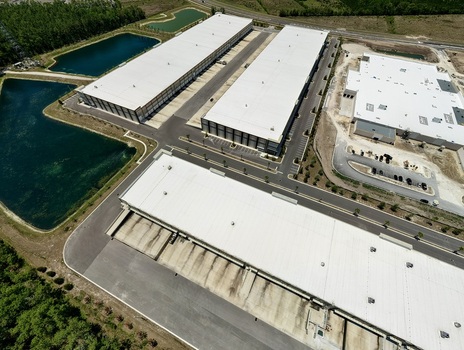 Aerial view of industrial warehouses with white rooftops and retention ponds near Saint Johns Parkway and International Golf Parkway World Golf Village Florida United States. Aerial view of industrial warehouses with white rooftops and retention ponds near Saint Johns Parkway and International Golf Parkway World Golf Village Florida United States.