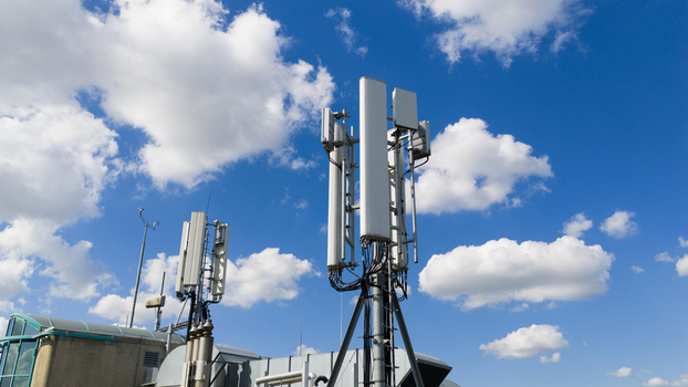 Aerial view of telecommunication antennas and cell towers on a rooftop under a bright blue sky with white clouds Amsterdam North Holland Netherlands. Aerial view of telecommunication antennas and cell towers on a rooftop under a bright blue sky with white clouds Amsterdam North Holland Netherlands.