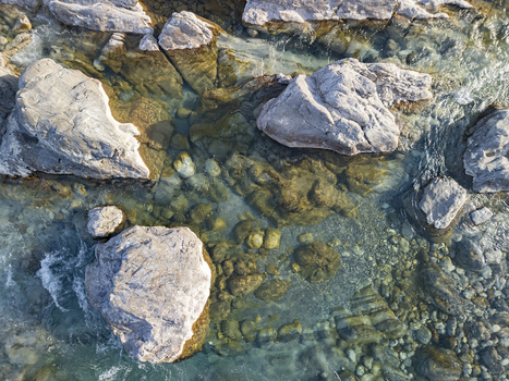 Aerial view of the clear waters of the Kiri River flowing over large smooth rocks and pebbles in Shkoder Qarku i Shkodres Albania. Aerial view of the clear waters of the Kiri River flowing over large smooth rocks and pebbles in Shkoder Qarku i Shkodres Albania.