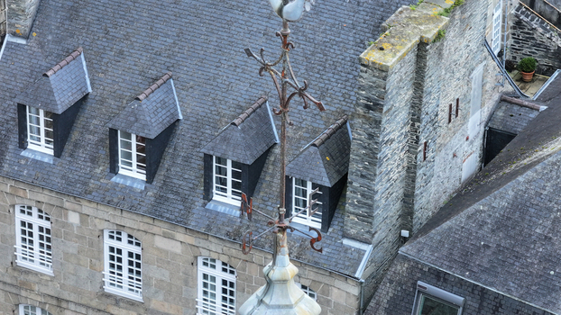 Aerial view of the slate rooftops and weather vane of Eglise Saint Melaine de Morlaix with stone walls and dormer windows Morlaix Bretagne France. Aerial view of the slate rooftops and weather vane of Eglise Saint Melaine de Morlaix with stone walls and dormer windows Morlaix Bretagne France.