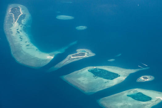 Aerial view of scattered islands and coral reefs create a mesmerizing mosaic against the deep blue sea Flight from Male to Hanimaadhoo island Maldives.