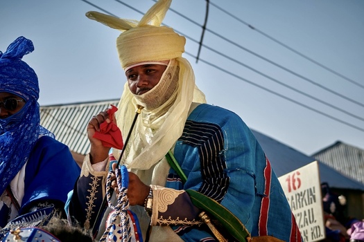 Zaria city Nigerian 21 March 2026 View of a regal figure in a vibrant blue robe and cream turban his face veiled under a brilliant sky. Zaria city Nigerian 21 March 2026 View of a regal figure in a vibrant blue robe and cream turban his face veiled under a brilliant sky.