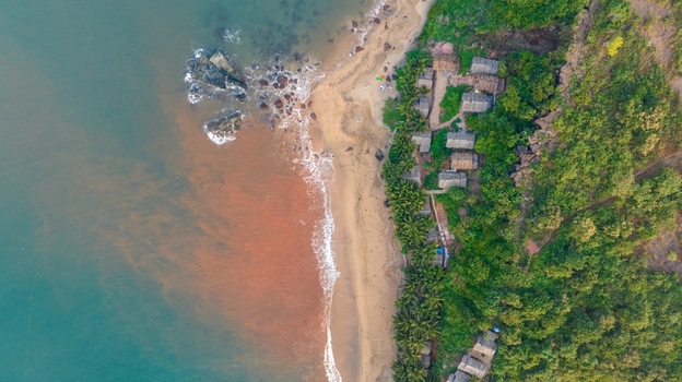 Aerial view of Cola Beach with its unique lagoon sandy shore rocky outcrops and lush green vegetation along the coastline in Kola Goa India. Aerial view of Cola Beach with its unique lagoon sandy shore rocky outcrops and lush green vegetation along the coastline in Kola Goa India.