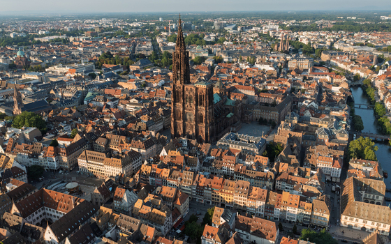 Aerial view of Cathedrale Notre Dame de Strasbourg surrounded by historic rooftops narrow streets and the Ill River in Strasbourg Grand Est France.