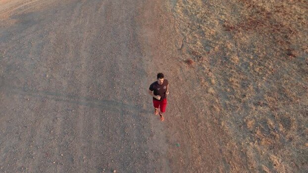 Aerial view of a man running on a dirt path in Caceres Spain.