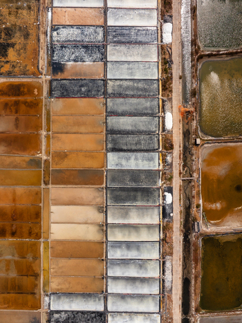 Aerial view of geometric salt evaporation ponds with varying water colors and textures in Vietnam. Aerial view of geometric salt evaporation ponds with varying water colors and textures in Vietnam.