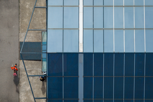 Aerial view of a modern building with a large glass roof and people walking on the adjacent pavement in Belgrade City of Belgrade Serbia. Aerial view of a modern building with a large glass roof and people walking on the adjacent pavement in Belgrade City of Belgrade Serbia.