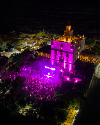 Mgarr Northern Region Malta 17 September 2026 Aerial view of Castello Zamittello illuminated in vibrant pink light during an outdoor night event with a crowd of people. Mgarr Northern Region Malta 17 September 2026 Aerial view of Castello Zamittello illuminated in vibrant pink light during an outdoor night event with a crowd of people.
