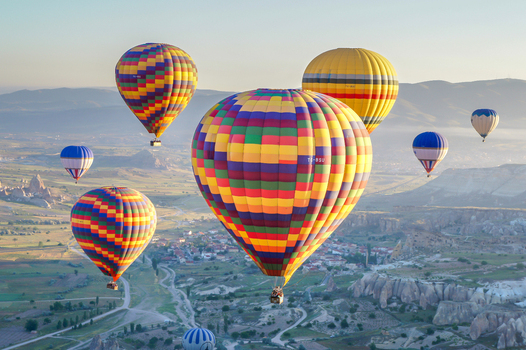 Aerial view of colorful hot air balloons floating over the unique rock formations and valleys of Cappadocia Kayseri Kayseri Turkiye.