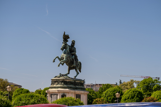 View of the equestrian statue of Archduke Charles at Heldenplatz surrounded by green trees under a clear blue sky in Vienna Vienna Austria. View of the equestrian statue of Archduke Charles at Heldenplatz surrounded by green trees under a clear blue sky in Vienna Vienna Austria.