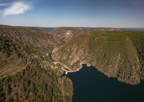 Aerial view of Encoro de Santo Estevo dam situated in a deep river canyon surrounded by dense green forests and rocky hills in Ourense Ourense Spain. Aerial view of Encoro de Santo Estevo dam situated in a deep river canyon surrounded by dense green forests and rocky hills in Ourense Ourense Spain.