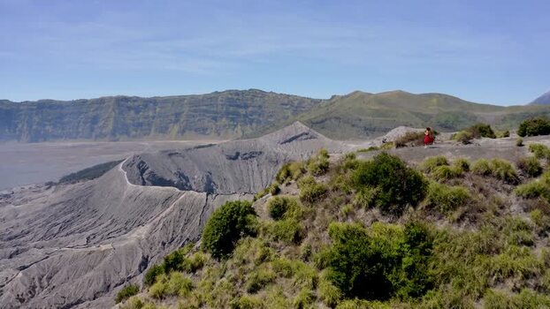 Aerial view of Mount Bromo and a person in a red dress Indonesia. Aerial view of Mount Bromo and a person in a red dress Indonesia.