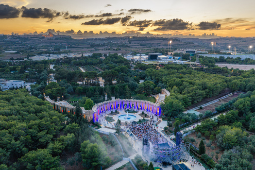 Attard Malta 20 September 2026 Aerial view of Ta Qali National Park featuring a large crowd gathered for an outdoor concert at sunset with illuminated structures and lush greenery. Attard Malta 20 September 2026 Aerial view of Ta Qali National Park featuring a large crowd gathered for an outdoor concert at sunset with illuminated structures and lush greenery.