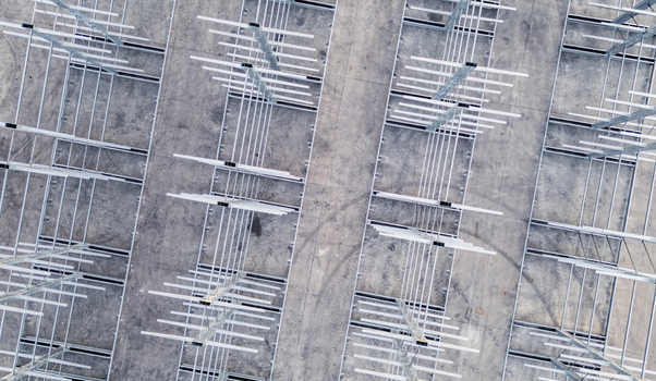 Aerial view of a multi level vehicle storage structure with metal framing on a concrete lot in Livron sur Drome Auvergne Rhone Alpes France.