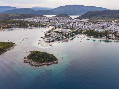 Aerial view of the coastal town of Ksamil featuring turquoise waters small islands and surrounding hills in Ksamil Vlore County Albania. Aerial view of the coastal town of Ksamil featuring turquoise waters small islands and surrounding hills in Ksamil Vlore County Albania.