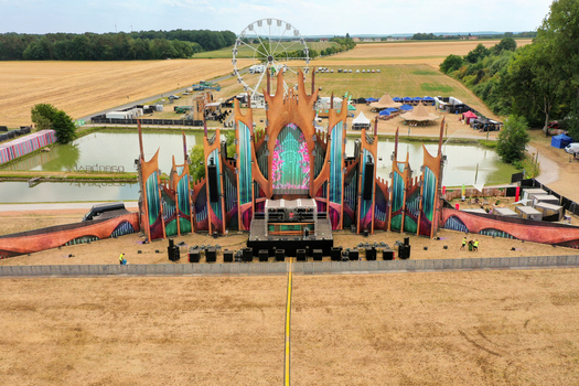 Herzogenaurach Germany 22 July 2022 Aerial view of the Open Beatz Festival main stage with a ferris wheel surrounding fields and people working on the site. Herzogenaurach Germany 22 July 2022 Aerial view of the Open Beatz Festival main stage with a ferris wheel surrounding fields and people working on the site.