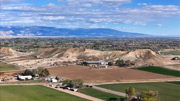 Aerial view of the stark contrast between the arid sculpted earth and the verdant fields below all under a vast sky Fruita Colorado United States. Aerial view of the stark contrast between the arid sculpted earth and the verdant fields below all under a vast sky Fruita Colorado United States.