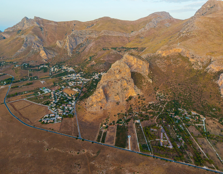 Aerial view of the rugged rocky mountain landscape with scattered houses winding roads and dry fields in the outskirts of Palermo Sicily Italy. Aerial view of the rugged rocky mountain landscape with scattered houses winding roads and dry fields in the outskirts of Palermo Sicily Italy.