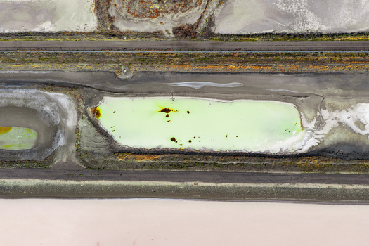 Aerial view of wastewater evaporation ponds by the Great Salt Lake featuring vibrant green water crystalized salt deposits and crusted earth textures in Ogden Utah United States. Aerial view of wastewater evaporation ponds by the Great Salt Lake featuring vibrant green water crystalized salt deposits and crusted earth textures in Ogden Utah United States.