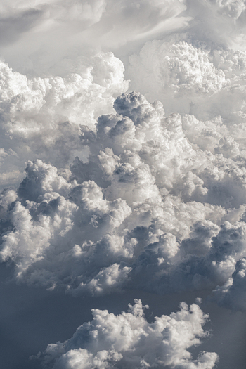 Aerial view of massive white cumulus clouds with dramatic textures and soft light at high altitude over India. Aerial view of massive white cumulus clouds with dramatic textures and soft light at high altitude over India.